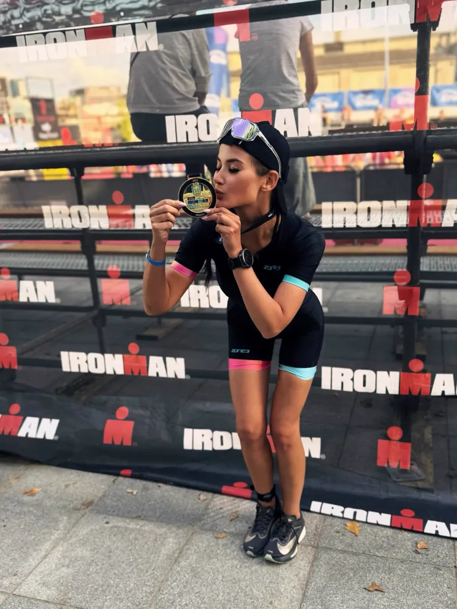 Olga Pabjan całuje medal po ukończeniu triathlonu Ironman 70.3 w Poznaniu